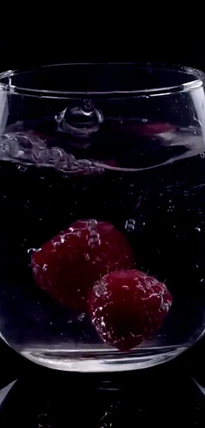 Raspberries splash into a glass of water creating a vibrant and refreshing scene.