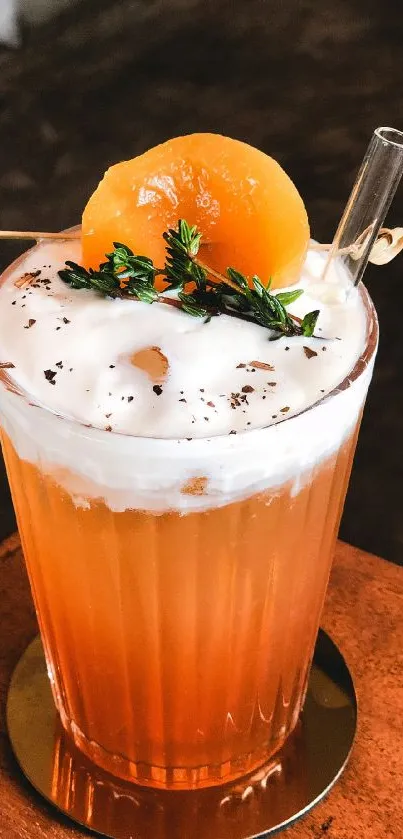 Orange cocktail with cream and peach garnish on wooden table.