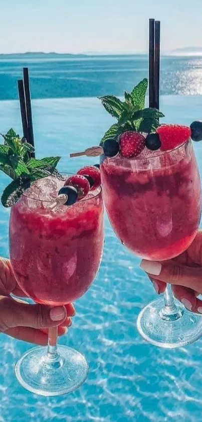 Two berry cocktails by a sunny poolside.