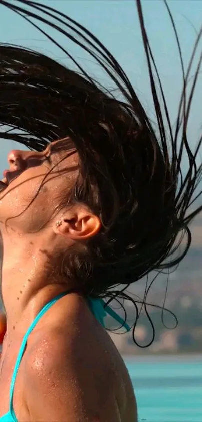 Woman flipping hair in a sunny poolside setting, enjoying summer.