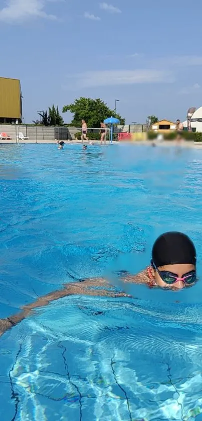 A swimmer enjoying a sunny day in a clear blue swimming pool.