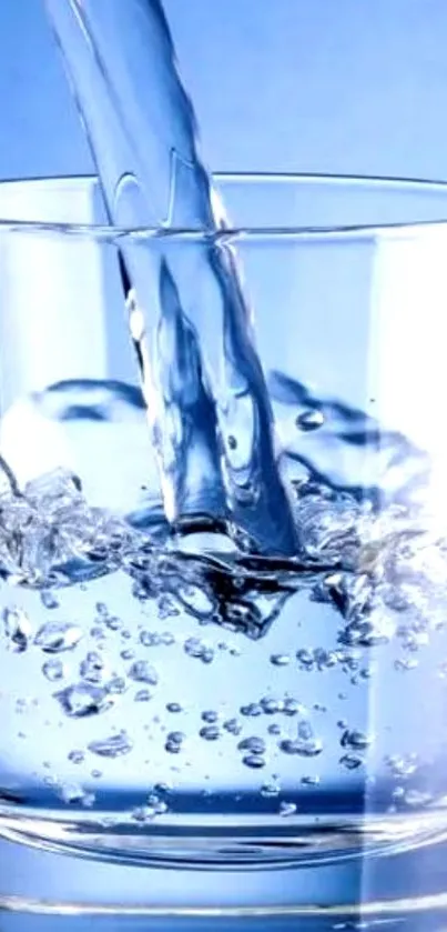 Refreshing water being poured into a clear glass with a blue background.