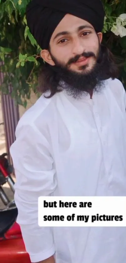 Man in a white outfit with green leafy background.