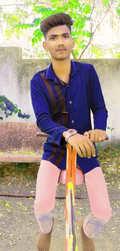 Young man in blue shirt outdoors on a vibrant sunny day.