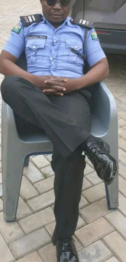 Police officer sitting relaxed in a chair outdoors in uniform.