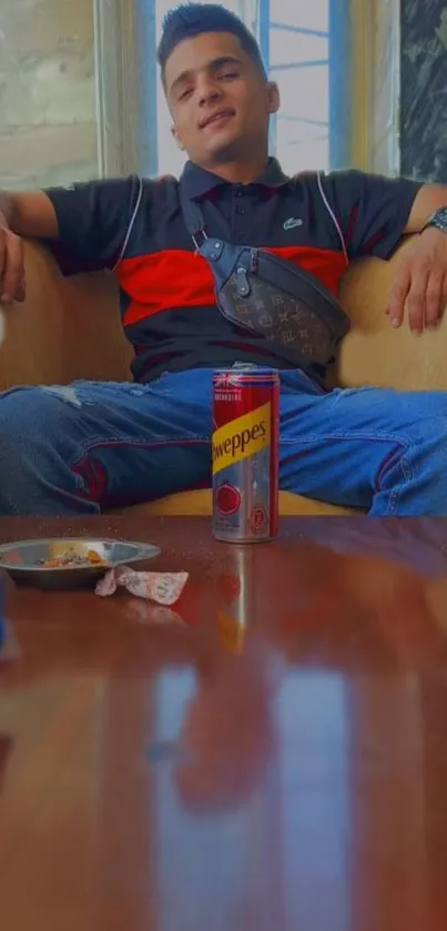 Young man relaxing with a soda can indoors.