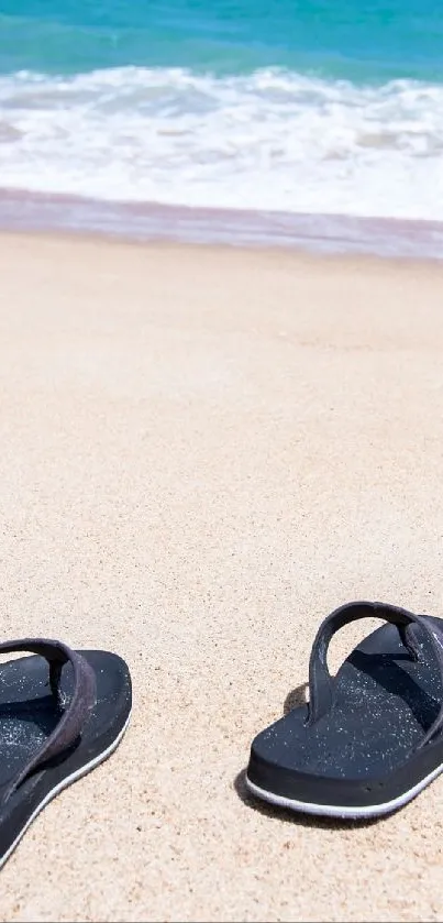 Flip-flops on sandy beach with ocean waves in the background.