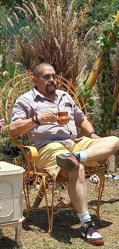 Man relaxing in a garden chair, sipping tea in the sunny outdoors.