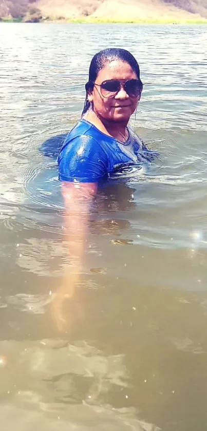 A woman enjoying a sunny day in the lake with natural surroundings.