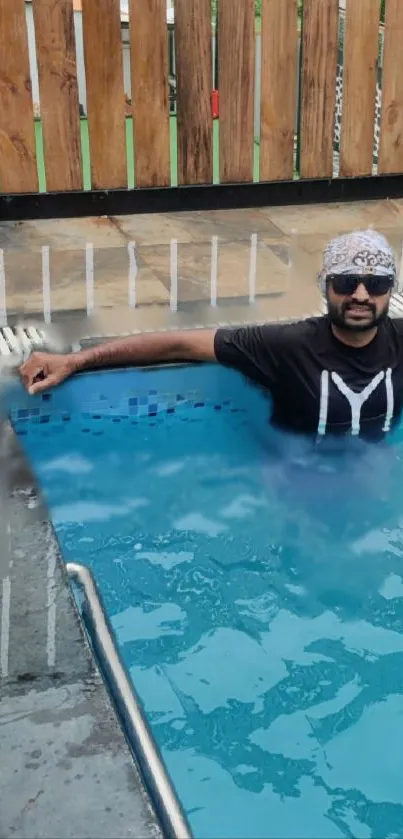 Man relaxing in a pool with sunglasses and headband, enjoying a sunny day.