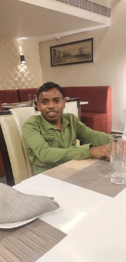 Young man in green shirt at restaurant table.