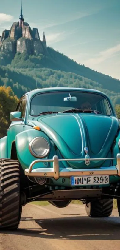 Teal vintage car with large tires in a mountain landscape.