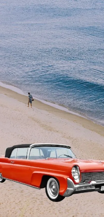 Classic red car on sandy beach with blue ocean backdrop.