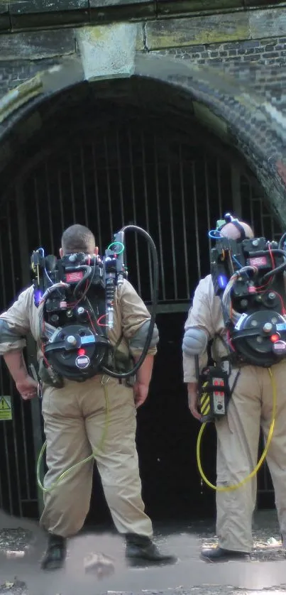 Ghost hunters in iconic costumes outside a darkened archway.