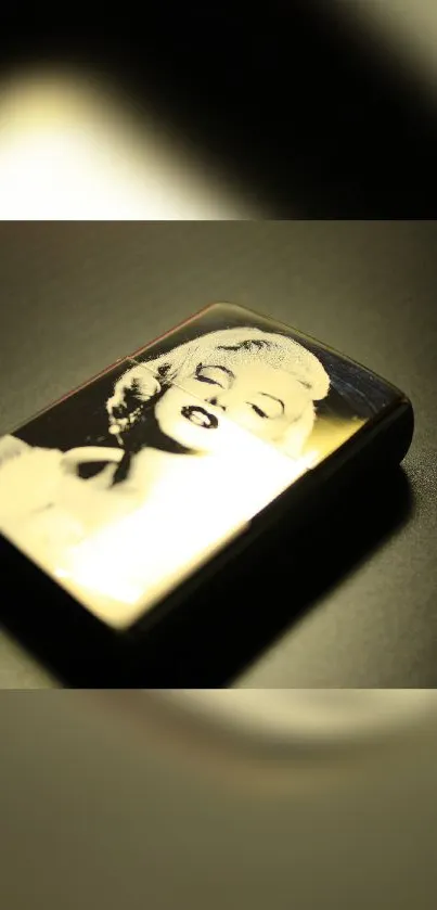 Vintage lighter with artistic portrait on dark background.