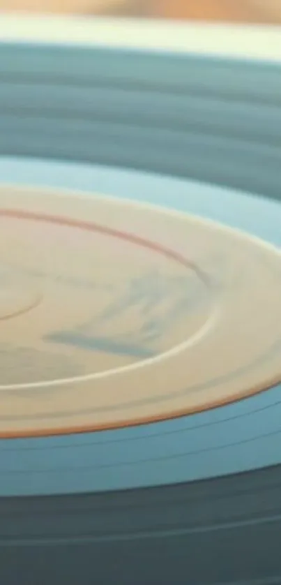 Close-up of a spinning vintage vinyl record in soothing light blue hues.