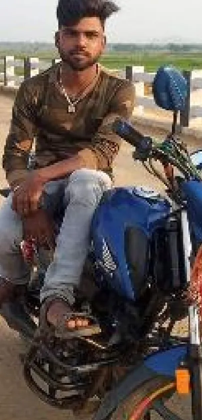 Man on a blue motorcycle on a rural road.