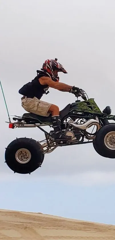 Rider performing a jump on an ATV in the desert.