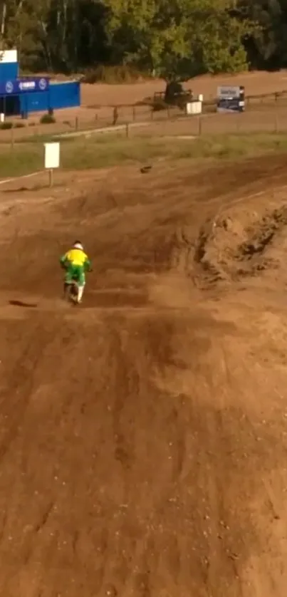 Motocross rider speeding on a dirt track in a scenic outdoor landscape.