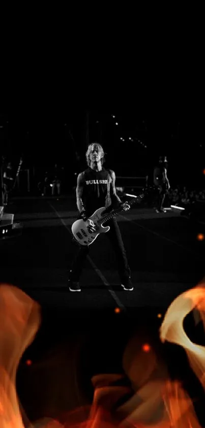 Guitarist performing on stage in black and white at a rock concert.