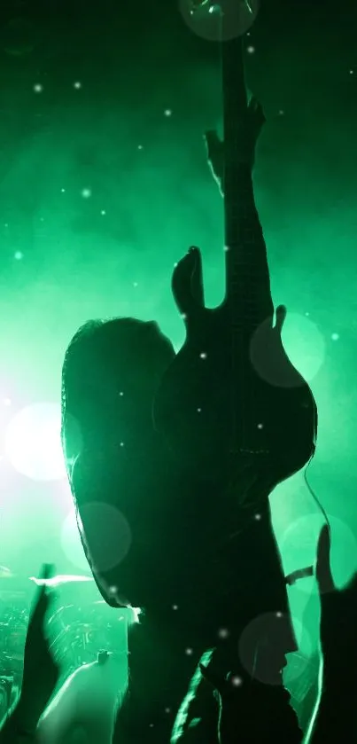 Silhouette of a guitarist at a rock concert with vibrant green lighting.