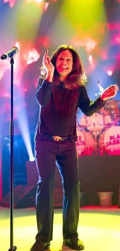 Performer on stage with vibrant yellow lights and band background.