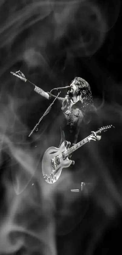 Black and white wallpaper of a guitarist performing on stage.