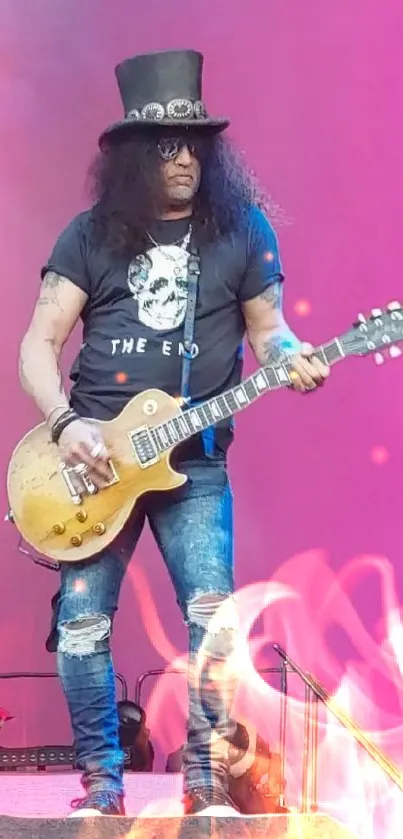 Rock guitarist performing live on pink stage.