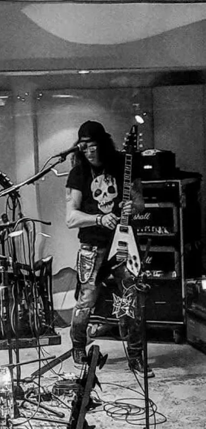 Musician in studio with guitar in moody black and white setting.