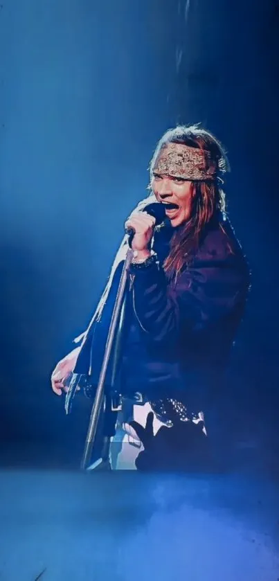 Rock star singing onstage with blue background.