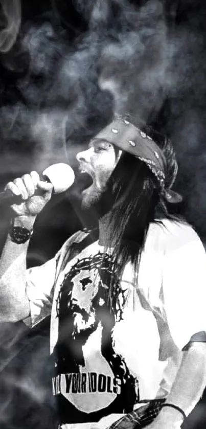 Singer performing on stage in black and white with smoky background.