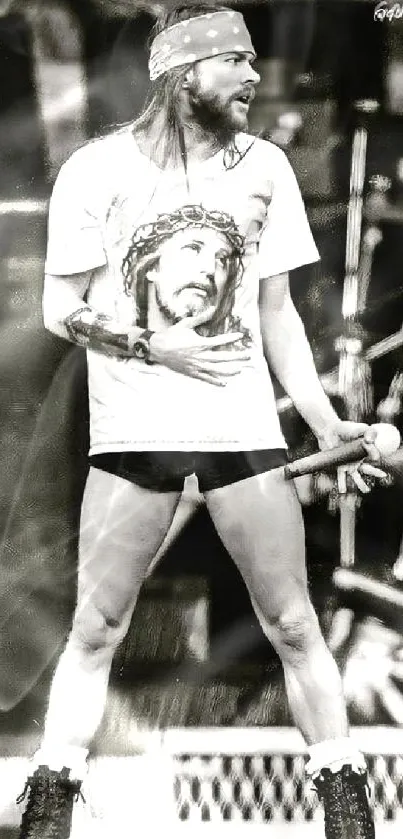 Monochrome rockstar on stage holding mic, wearing graphic t-shirt.