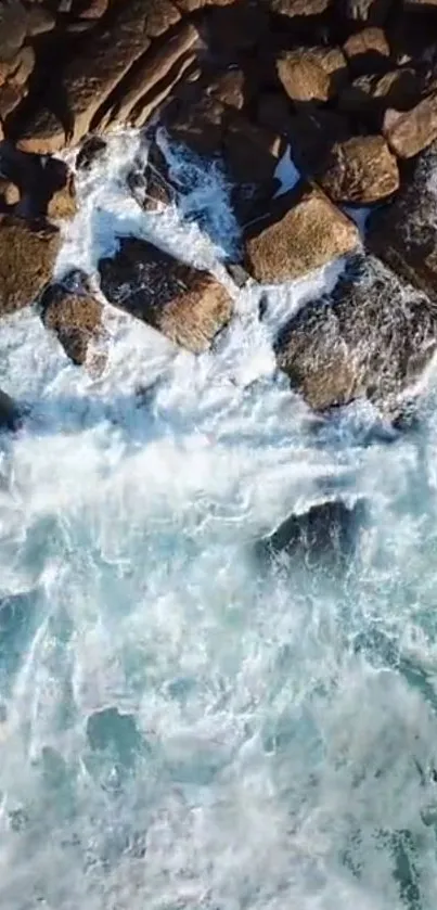 Aerial view of ocean waves crashing against rocky shoreline.