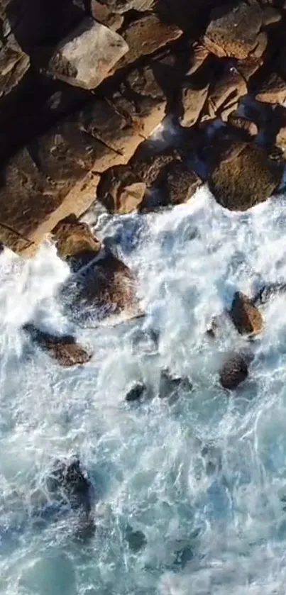 Aerial view of waves crashing against rocky coastline.