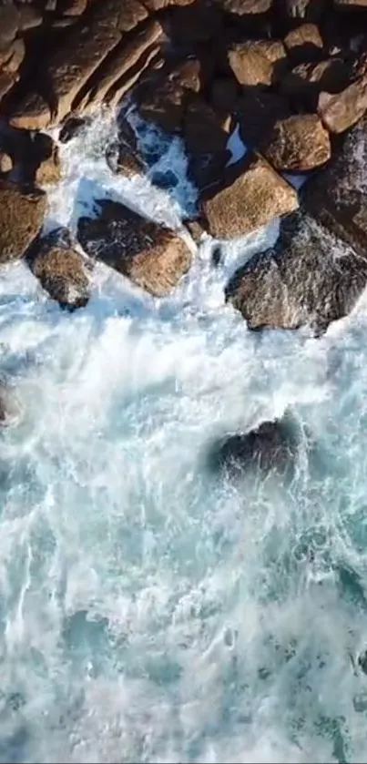 Aerial view of waves crashing against rocky coastline, showcasing ocean's power and beauty.