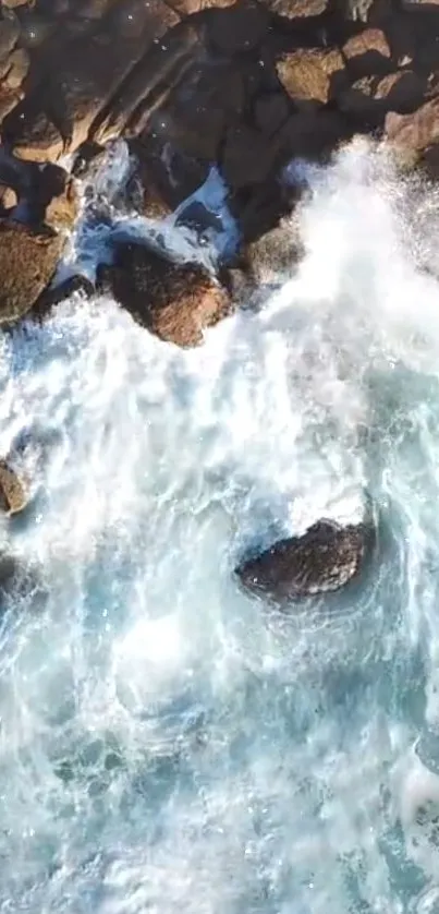 Aerial view of ocean waves hitting rocky cliffs.