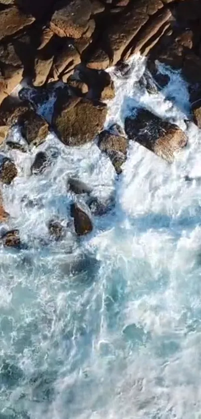 Aerial view of ocean waves crashing on rugged rocky shore.