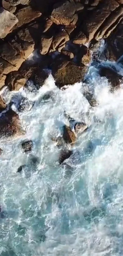 Aerial view of waves crashing against rocky cliffs.