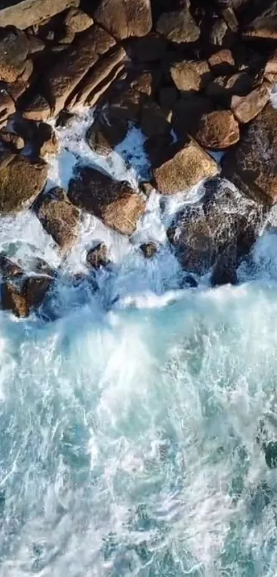 Aerial view of waves crashing against rocky shoreline.