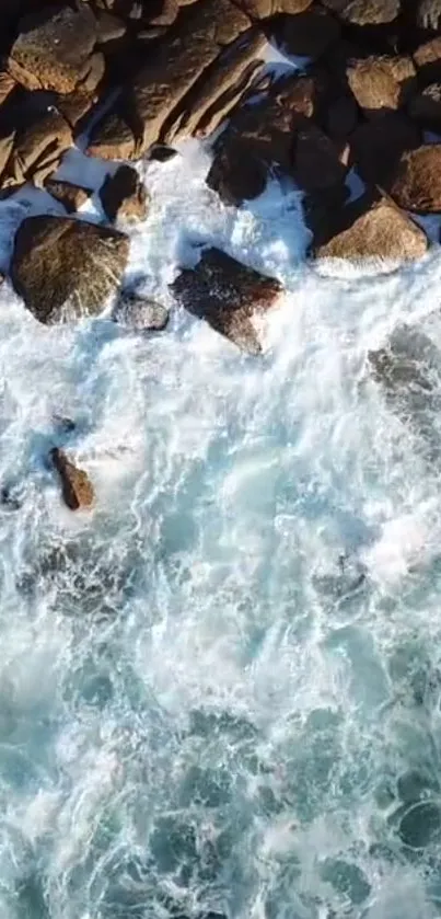 Aerial view of rocky shoreline with crashing blue waves.