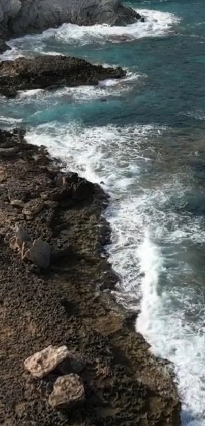 Rocky shoreline with ocean waves under teal skies.