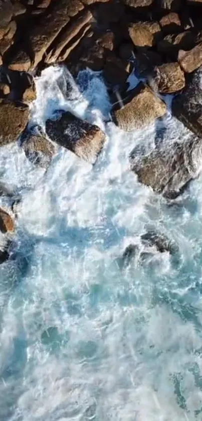 Aerial view of ocean waves crashing against rocky shore.