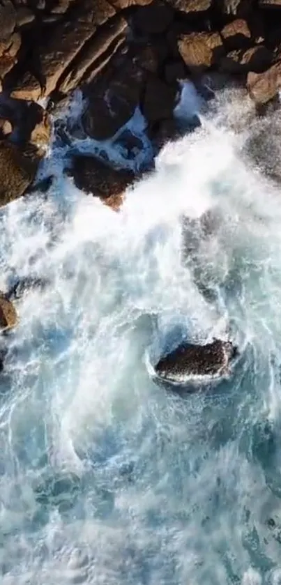 Aerial view of waves crashing onto rugged rocks.