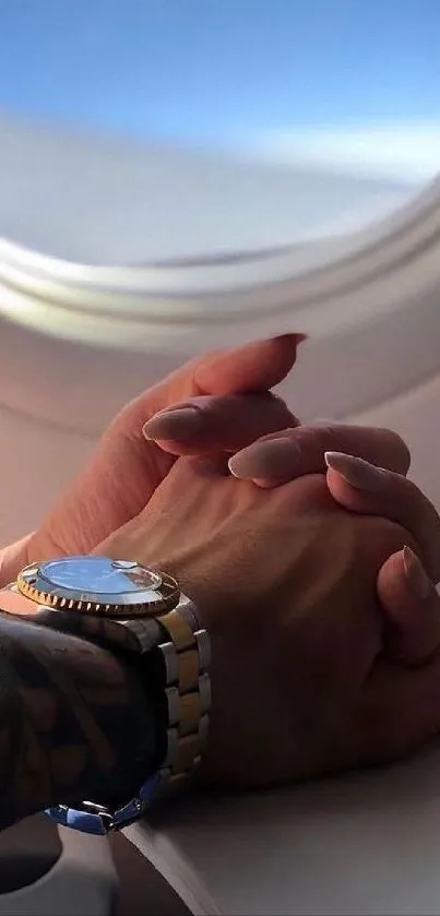 Romantic handholding in airplane window view.