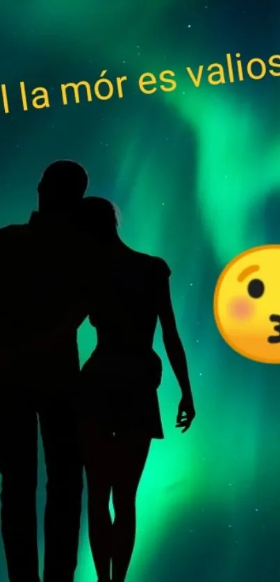 Silhouette couple under green aurora with a kiss emoji.