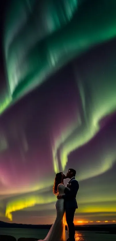 Couple kissing under glowing Northern Lights.