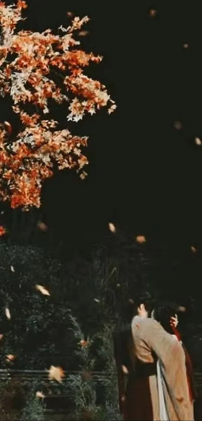 Romantic couple under falling autumn leaves at night.