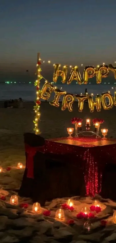 Romantic beach birthday setup with candles and lights on sand.