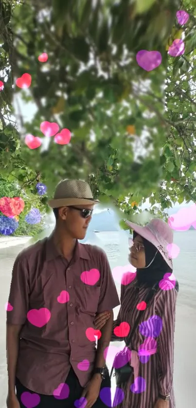 Couple on a serene beach with colorful hearts.