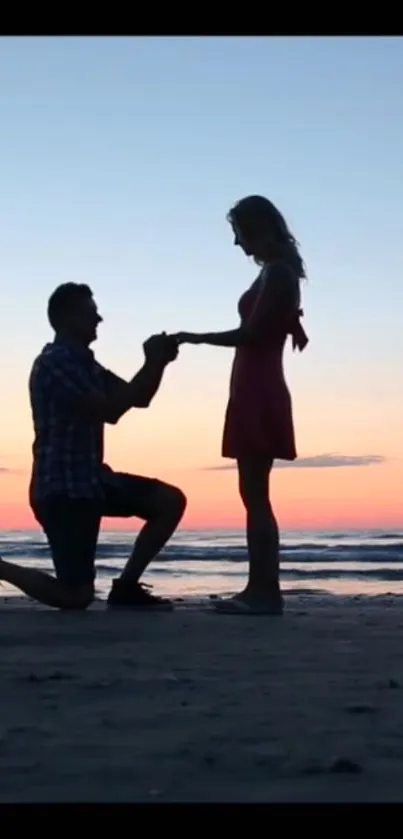 Silhouette of a proposal at sunset on a beach with a serene ocean backdrop.